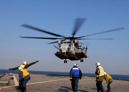 US Navy 091105-N-6692A-055 A Sailor signals a Marine Corps CH-53 Sea Stallion helicopter as it takes off from the flight deck of USS Tortuga (LSD 46) photo