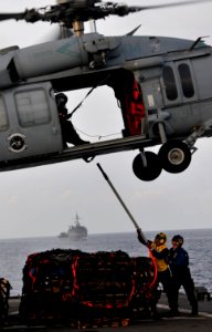 US Navy 091106-N-0807W-367 Boatswain's Mate 3rd Class Christopher L. Ellis, left, and Seaman Kayla L. Gravdal connect a hoisting sling to an MH-60S Sea Hawk helicopter aboard the amphibious dock landing ship USS Harpers Ferry (