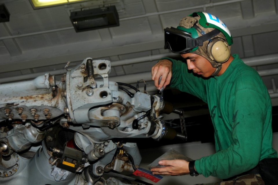US Navy 091108-N-3038W-073 Aviation Machinist's Mate 3rd Class Joseph Rosario, assigned to the Indians of Helicopter Anti-Submarine Squadron (HS) 6, performs maintenance on the main rotor hub of an HH-60H Sea Hawk helicopter