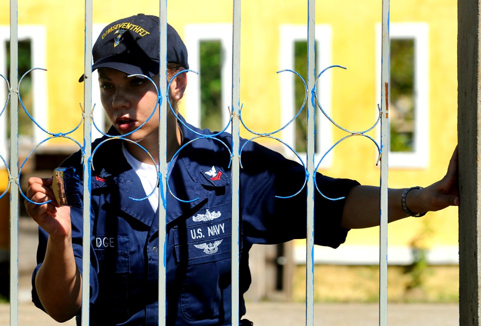 US Navy 091108-N-7280V-646 Operations Specialist 2nd Class Lesha Aldridge, assigned to the U.S. 7th Fleet Staff, paints a playground fence during a community outreach project at To Hien Thanh Elementary School