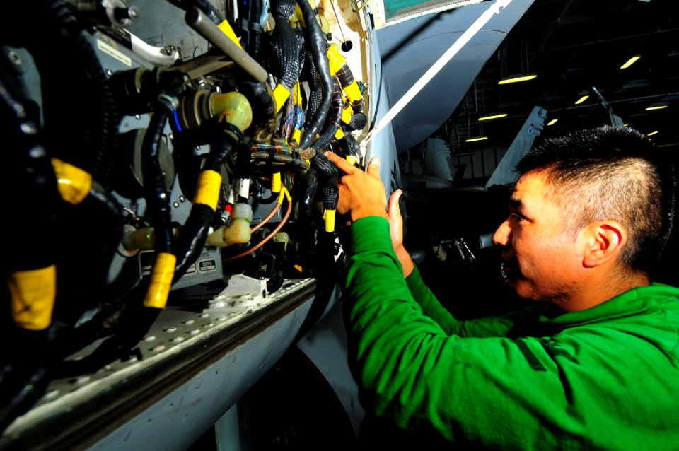 US Navy 091111-N-4053P-001 Aviation Electronics Technician 3rd Class Randy Whitehorse troubleshoots equipment on an F-A-18C Hornet