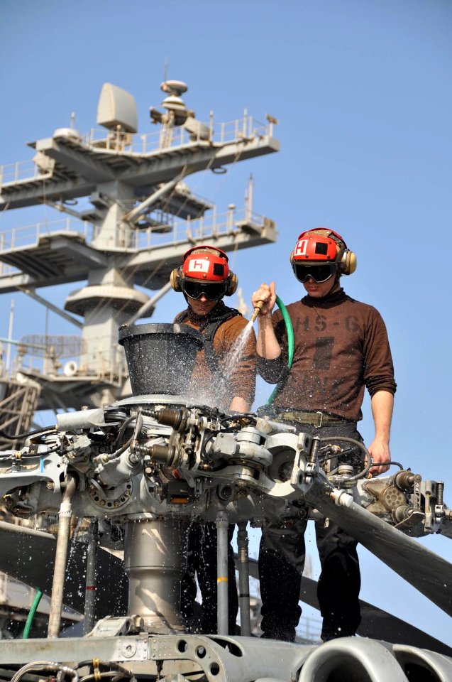 US Navy 091113-N-8421M-003 Machinist's Mate Airman Matthew Sargent and Airman Ian Brown wash down an HH-60H Sea Hawk helicopter