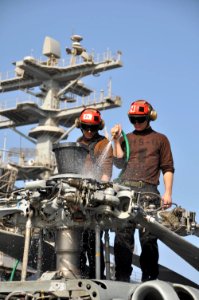 US Navy 091113-N-8421M-003 Machinist's Mate Airman Matthew Sargent and Airman Ian Brown wash down an HH-60H Sea Hawk helicopter