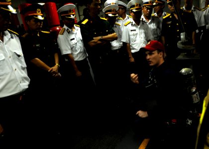 US Navy 091109-N-3830J-229 Hull Maintenance Technician 1st Class Thomas Kiefer, assigned to the amphibious command ship USS Blue Ridge (LCC 19), demonstrates how to use a self-contained breathing apparatus to Vietnam navy offic