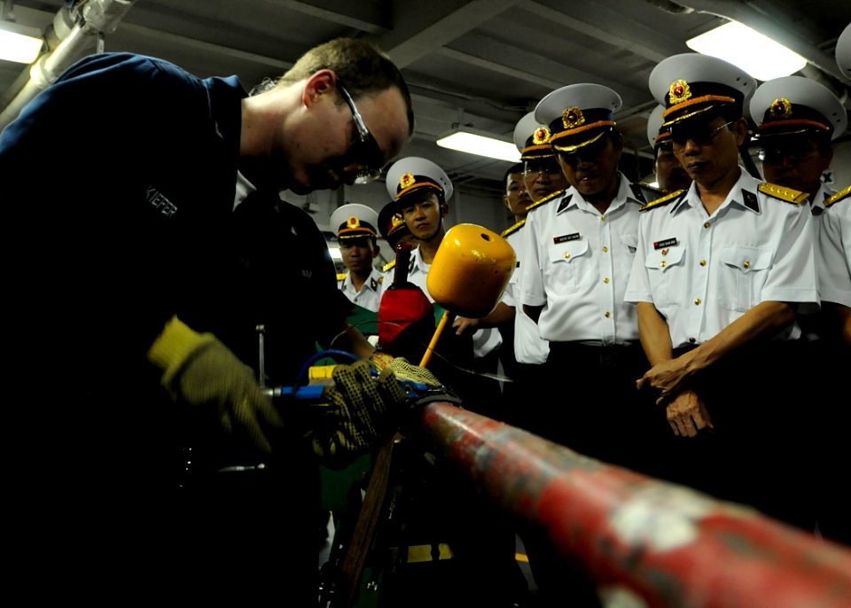 US Navy 091109-N-3830J-225 Hull Maintenance Technician 1st Class Thomas Kiefer, assigned to the amphibious command ship USS Blue Ridge (LCC 19), demonstrates pipe patching to Vietnam navy officers assigned to Naval Zone 3 durin