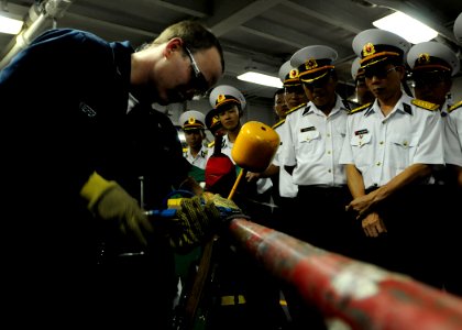 US Navy 091109-N-3830J-225 Hull Maintenance Technician 1st Class Thomas Kiefer, assigned to the amphibious command ship USS Blue Ridge (LCC 19), demonstrates pipe patching to Vietnam navy officers assigned to Naval Zone 3 durin