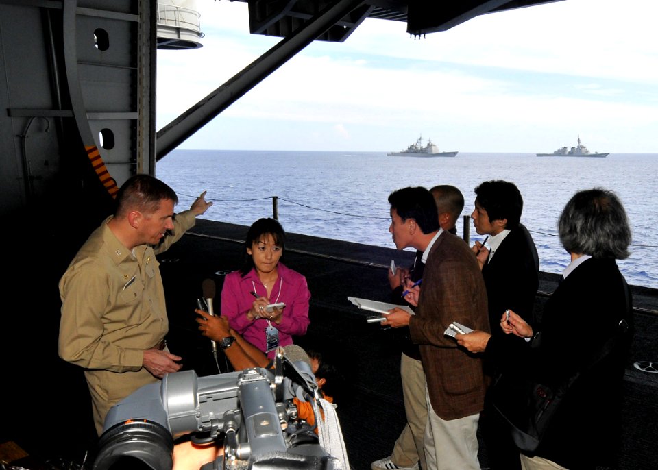 US Navy 091113-N-1062H-042 Capt. Charles Williams, commodore of Destroyer Squadron (DESRON) 15, is interviewed by Japanese media in the hangar bay of the aircraft carrier USS George Washington (CVN 73)