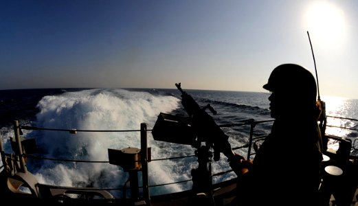 US Navy 091108-N-9500T-152 Fire Controlman 3rd Class Lacey Robertson mans a .50-caliber machine gun on the fantail of the guided-missile cruiser USS Chosin (CG 65) as the ship conducts counter-piracy operations in the Gulf of A