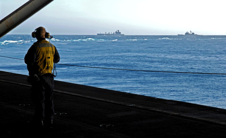 US Navy 091114-N-4954I-009 Aviation Boatswain's Mate (Handling) 2nd Class Michael Kiger watches USS Princeton (CG 59) transit towards USNS Guadalupe (T-AO 200)