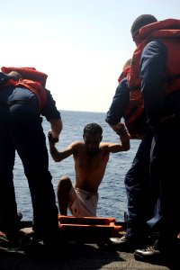 US Navy 091117-N-9500T-579 The first of three men that were rescued from the water of the Gulf of Aden is helped aboard USS Chosin (CG 65)