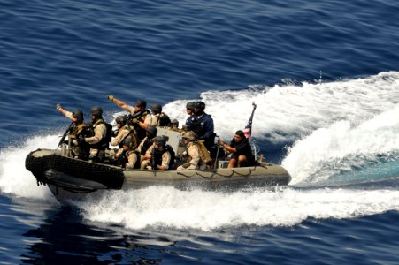 US Navy 091112-N-9500T-121 A visit, board, search and seizure team from the guided-missile cruiser USS Chosin (CG 65) point to a suspected pirate dhow as they make their approach to board it during counter-piracy operations in