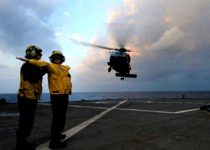 US Navy 091116-N-7478G-152 Boatswain's Mate 3rd Class Christine Bagley guides Boatswain's Mate 1st Class Danielle Villa with her hand signals during the launch of an SH-60F Sea Hawk