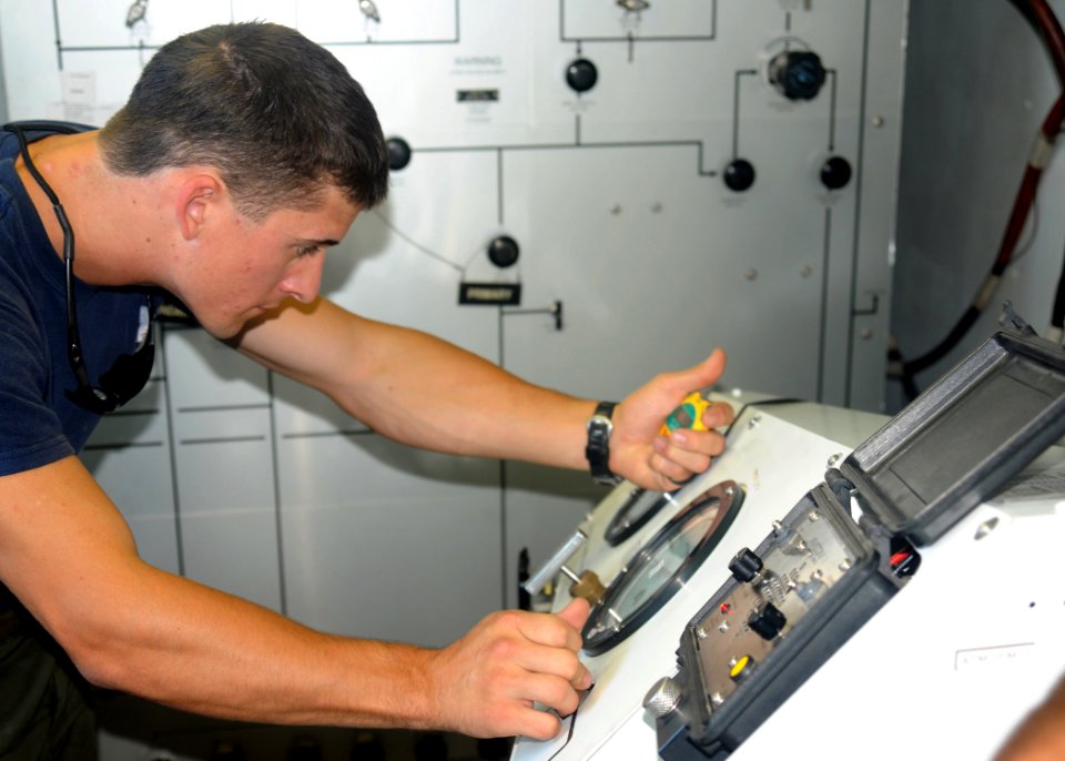 US Navy 091117-N-1291E-102 Navy Diver 2nd Class Ryan Arnold monitors the decompression chamber during a simulated medical emergency