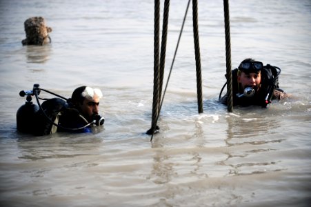 US Navy 091116-N-4154B-071 Navy Diver 2nd Class Zachery Dojaquez and an Iraqi Navy diver work together to run lifting wires from a crane to a sunken barge