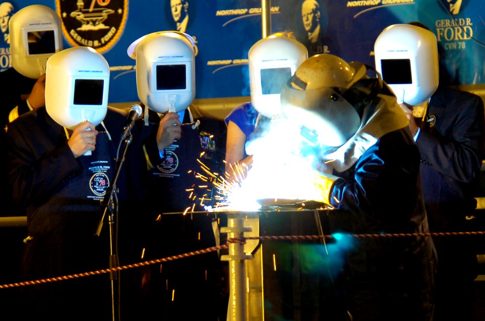 US Navy 091114-N-0924R-003 Robert Bowker, a structural welder with Northrop Grumman Shipbuilding, welds the initials of Susan Ford Bales into the keel of the aircraft carrier Gerald R. Ford (CVN 78)