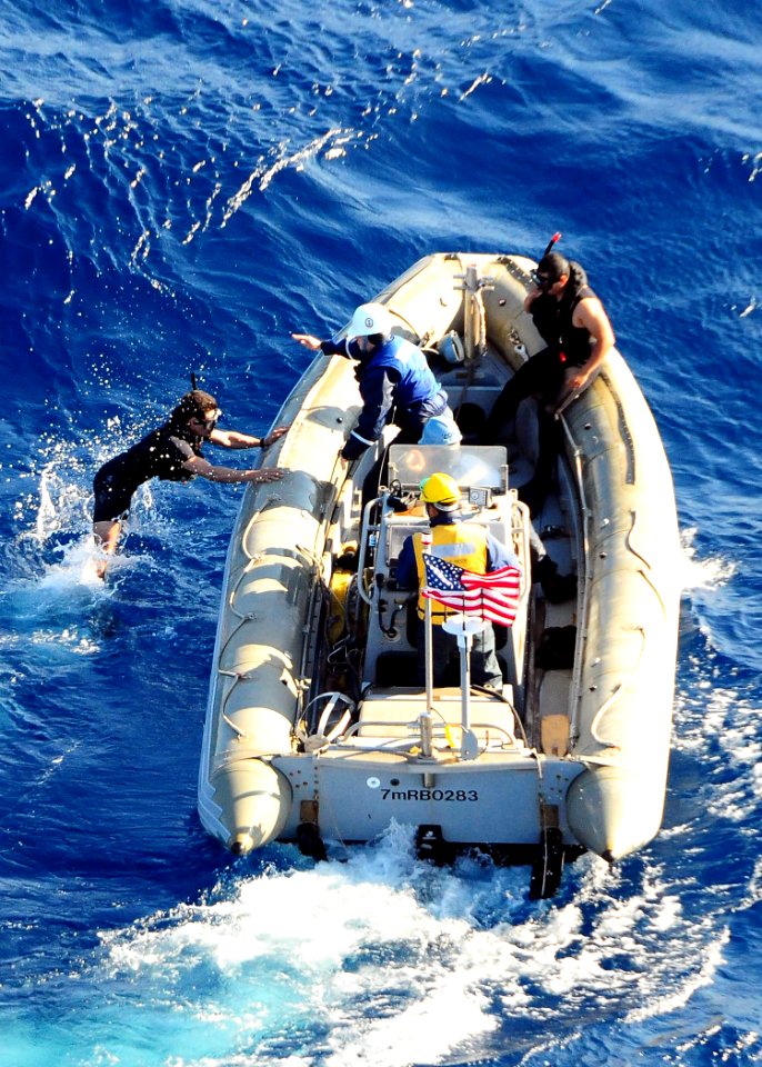 US Navy 091120-N-1644H-146 Sailors assigned to the guided-missile destroyer USS Curtis Wilbur (DDG 54) enter the water to recover an exercise torpedo dropped by an SH-60B Sea Hawk Helicopter