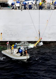 US Navy 091120-N-1644H-319 Sailors assigned to the guided-missile destroyer USS Curtis Wilbur (DDG 54) recover an exercise torpedo dropped by an SH-60B Sea Hawk Helicopter