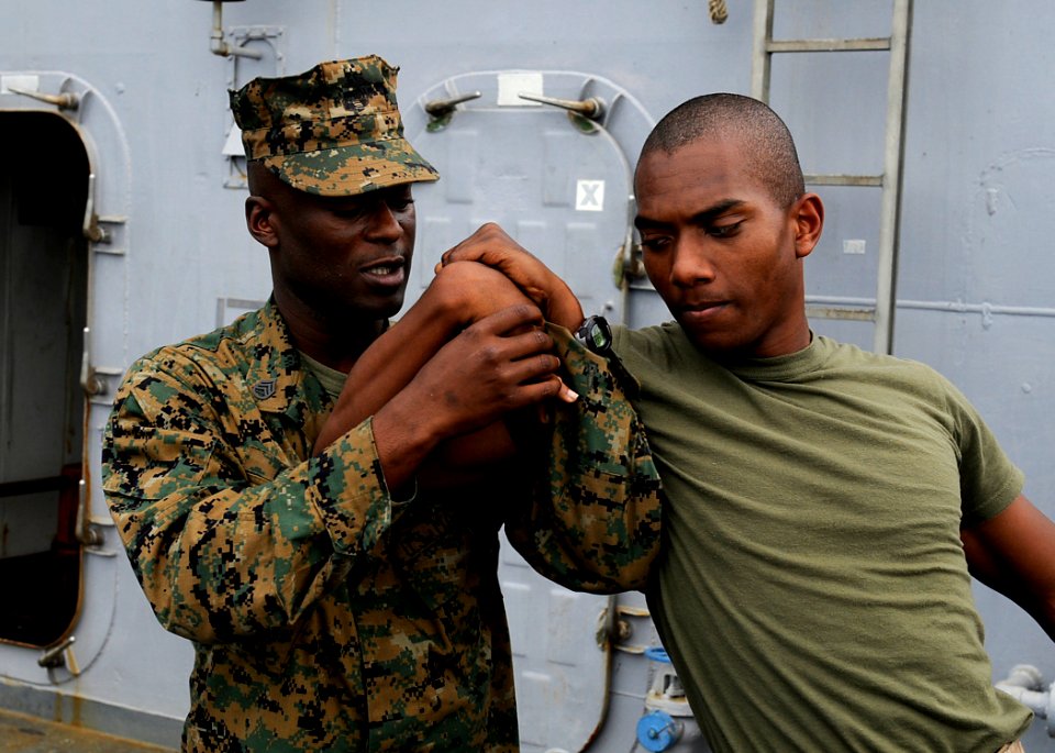 US Navy 091116-N-7280V-210 Staff Sgt. Gerald Fuller, assigned to Fleet Antiterrorism Security Team Pacific (FASTPAC) Company, 5th Platoon, teaches Cpl. Glenn Hughes tactical movements aboard the amphibious command ship USS Blue