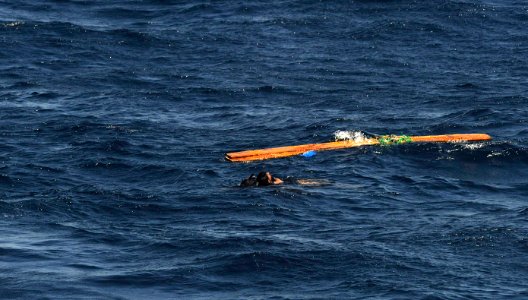US Navy 091117-N-9500T-298 Search and Rescue Swimmer Gas Turbine Systems Mechanic 2nd Class Alfredo Rodriguez buddy-tows the last of three men that were clinging to a piece of wood in the Gulf of Aden