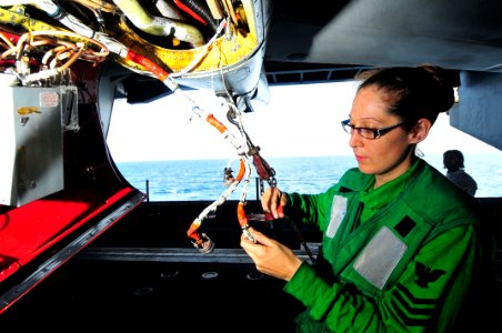US Navy 091124-N-4053P-002 Aviation Electronics Technician 1st Class Kristina Perham, assigned to the Black Ravens of Electronic Attack Squadron (VAQ) 135, spot ties wiring on an EA-6B Prowler