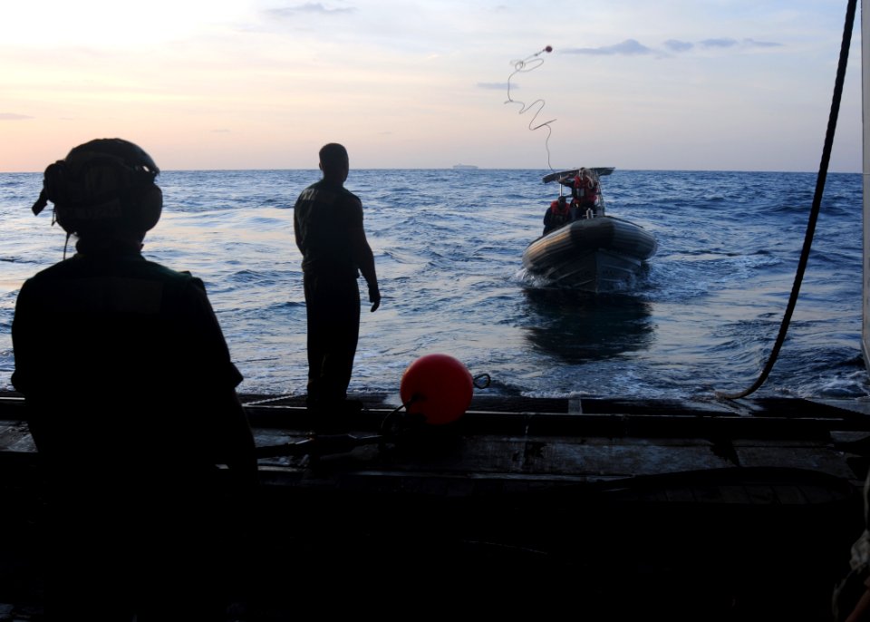 US Navy 091121-N-1291E-026 Members of Helicopter Mine Countermeasures Squadron (HM) 15 in a rigid hull inflatable boat (RHIB) throw a line to Aviation Electronics Technician Airman Anthony Skubon to launch a MK-105 Mod 4 Sled