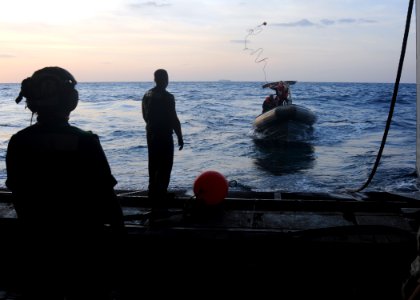 US Navy 091121-N-1291E-026 Members of Helicopter Mine Countermeasures Squadron (HM) 15 in a rigid hull inflatable boat (RHIB) throw a line to Aviation Electronics Technician Airman Anthony Skubon to launch a MK-105 Mod 4 Sled