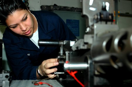 US Navy 091124-N-8960W-010 Gunner's Mate Seaman Alexandria Shaw inspects a 50-cal. machine gun aboard the aircraft carrier USS Nimitz (CVN 68)