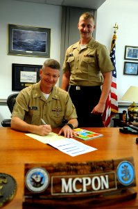 US Navy 091118-N-9818V-048 Seaman James Vidal gives Master Chief Petty Officer of the Navy (MCPON) Rick West the 2009 Combined Federal Campaign donation forms to fill out