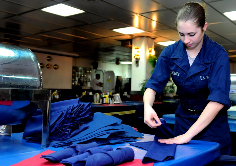 US Navy 091118-N-7478G-163 Culinary Specialist Seaman Dulce Looney folds napkins in the wardroom