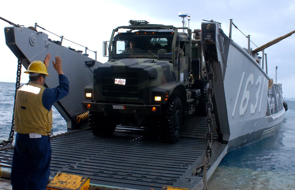 US Navy 091118-N-6692A-026 Boatswain's Mate 2nd Class Carlos Gonzales guides a 7-ton Marine Corps truck