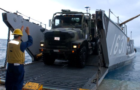 US Navy 091118-N-6692A-026 Boatswain's Mate 2nd Class Carlos Gonzales guides a 7-ton Marine Corps truck