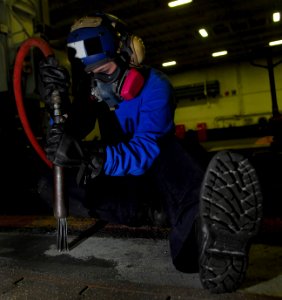 US Navy 091121-N-2475A-082 Aviation Boatswain's Mate (Handling) Airman Recruit Kristee Petersen grinds paint from a deck edge