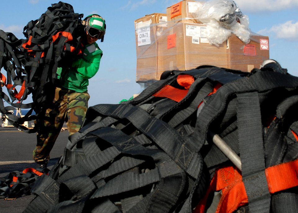 US Navy 091120-N-1062H-003 Logistics Specialist 2nd Class Reggie Guevarra stacks cargo netting aboard the aircraft carrier USS George Washington (CVN 73) during a vertical replenishment at sea