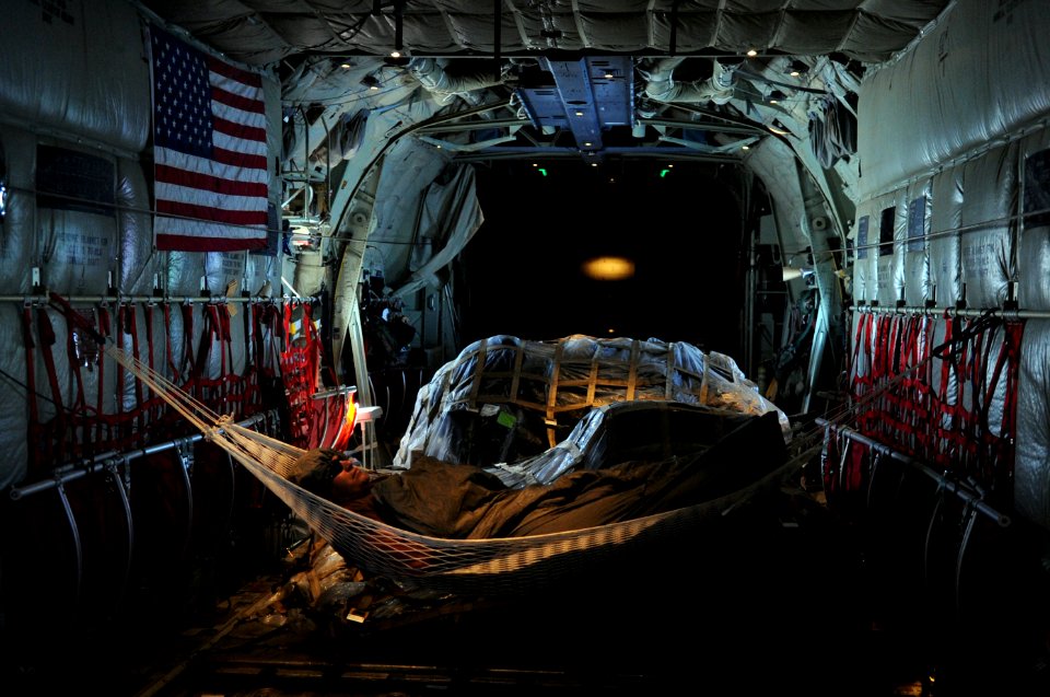 US Navy 091122-N-4154B-010 Explosive Ordnance Disposal Technician 2nd Class Edwin Sharpe rests in a hammock in the cabin of a U.S. Air Force C-130 airplane