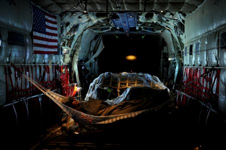 US Navy 091122-N-4154B-010 Explosive Ordnance Disposal Technician 2nd Class Edwin Sharpe rests in a hammock in the cabin of a U.S. Air Force C-130 airplane