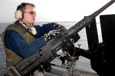 US Navy 091128-N-8960W-009 Gunner's Mate 3rd Class Daniel Smith stands ready behind a .50-caliber machine gun during a training evolution aboard the aircraft carrier USS Nimitz (CVN 68)