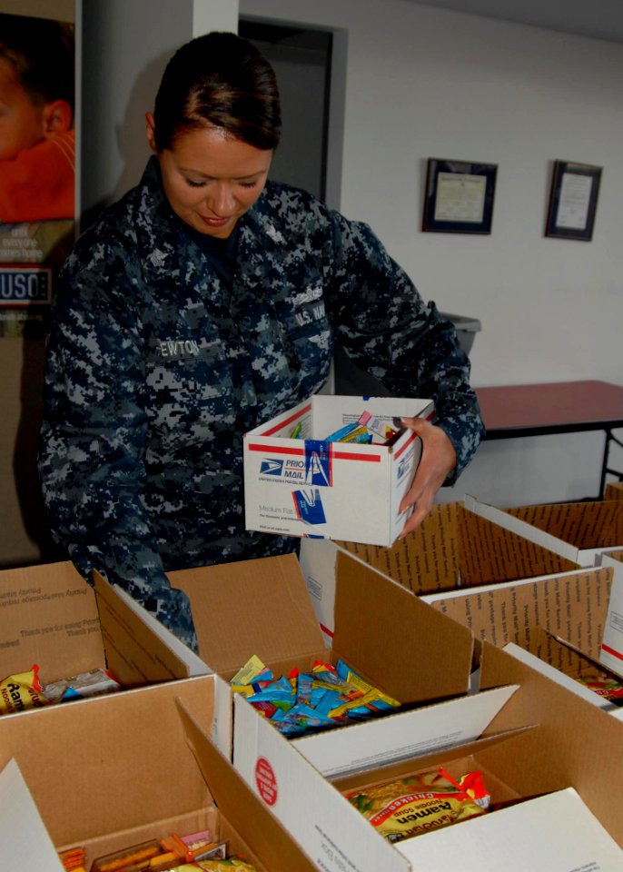US Navy 091129-N-5812W-002 Mass Communication Specialist 1st Class Heather Ewton packs care packages at the local USO