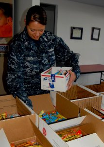 US Navy 091129-N-5812W-002 Mass Communication Specialist 1st Class Heather Ewton packs care packages at the local USO