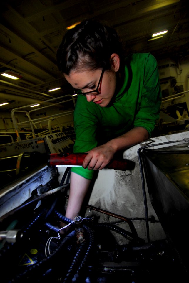 US Navy 091203-N-2475A-006 Aviation Support Equipment Technician Airman Heather Mikschl attaches a flex plate on an aircraft towing tractor transmission