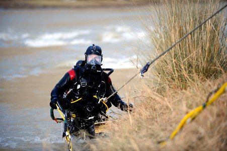 US Navy 091127-N-4154B-071 Navy Diver 2nd Class Zachery Dojaquez, assigned to Mobile Diving and Salvage Unit (MDSU) 2, is pulled out of the water after his dive during a search for the body of U.S. Army Sgt. Brandon Islip