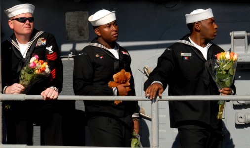 US Navy 091204-N-2456S-079 Fire Controlman 1st Class Jim Buckles, left, Gunner's Mate 2nd Class Al Spivey and Gunner's Mate 3rd Class Charles Talbert wait to reunite with their families