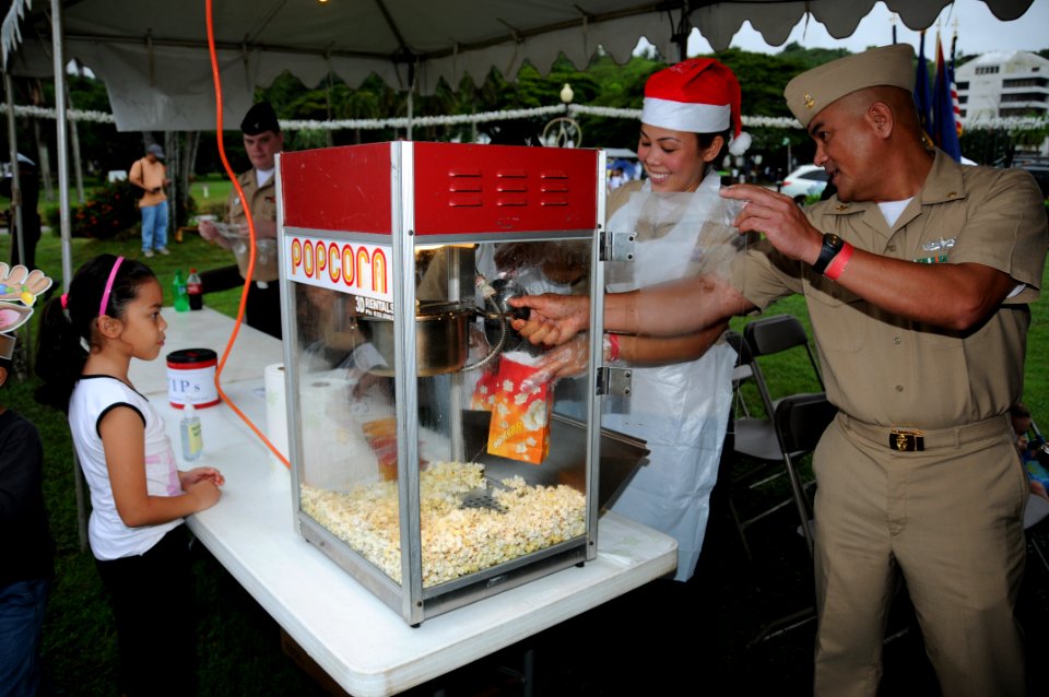 US Navy 091128-N-1906L-002 Chief Culinary Specialist Rodrigo Sabanga and Hospital Corpsman 2nd Class Jade Zimmerman ready a bag of popcorn for attendees of the Guam Chamber of Commerce's 17th Annual Christmas Festival