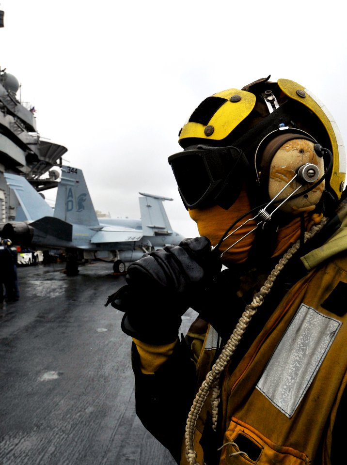 US Navy 091205-N-6003P-426 An aircraft director communicates with flight deck control on the flight deck of the aircraft carrier USS Harry S. Truman (CVN 75). Harry S. Truman is underway conducting carrier qualifications