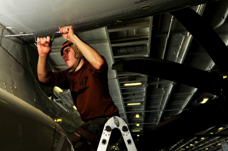 US Navy 091128-N-4053P-009 Aviation Structural Mechanic Fernando Mendez, assigned to the Wallbangers of Airborne Early Warning Squadron (VAW) 117, removes a panel during a 400-hour inspection aboard the aircraft carrier USS Nim