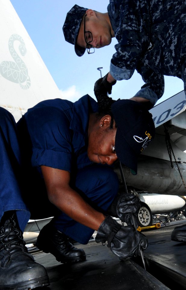 US Navy 091203-N-3038W-048 Aviation Boatswain's Mate (Equipment) Airman Latia Davis and Aviation Boatswain's Mate (Equipment) Airman Kevin Rooker perform maintenance on a catapult