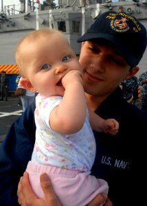 US Navy 091203-N-2456S-054 Gas Turbine System Technician (Mechanical) Fireman Christian Harvey holds his nine-month old daughter