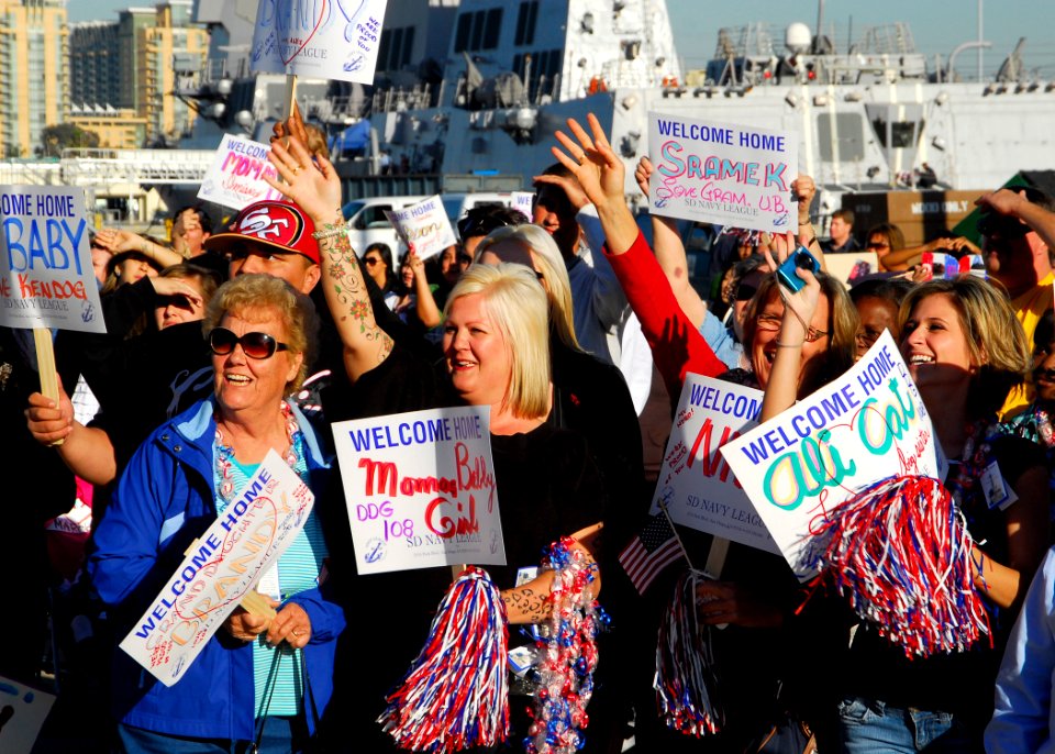 US Navy 091204-N-0209M-004 Family members and friends hold signs and cheer as the Arleigh Burke-class missile destroyer USS Wayne E. Meyer (DDG 108) arrives at its new homeport of San Diego after transiting from the Bath Iron W
