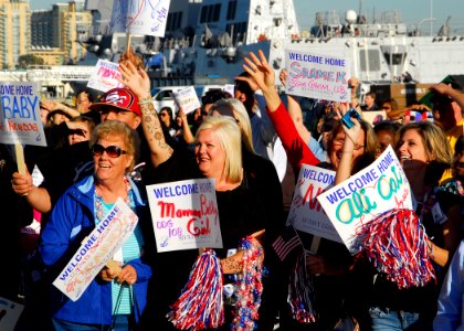 US Navy 091204-N-0209M-004 Family members and friends hold signs and cheer as the Arleigh Burke-class missile destroyer USS Wayne E. Meyer (DDG 108) arrives at its new homeport of San Diego after transiting from the Bath Iron W