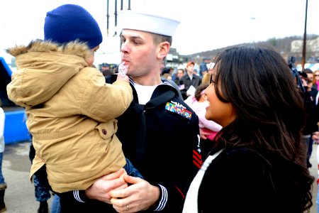 US Navy 091202-N-8467N-004 Electronics Technician 1st Class Charles Simonds shares a candy cane with his son while his wife looks on