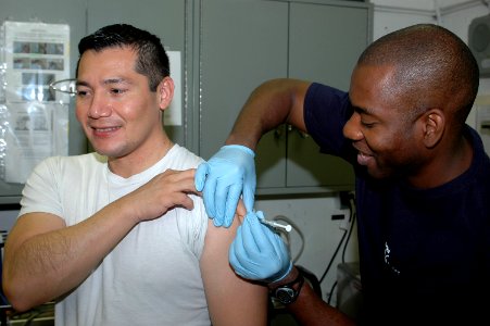 US Navy 091129-N-8960W-064 Hospital Corpsman Michael Parke gives a vaccine to Lt. Carlos Lopez aboard the aircraft carrier USS Nimitz (CVN 68) photo